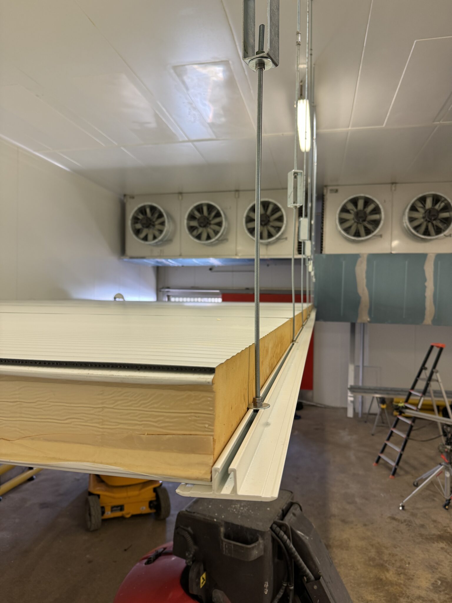 Pose d'une chambre froide par ISONEO lors d'un chantier montrant le détail des panneaux sandwich isothermes soutenu par T porteur